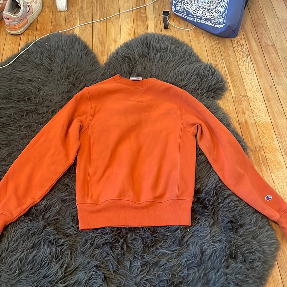 Dark orange colored tight fitting crew neck.